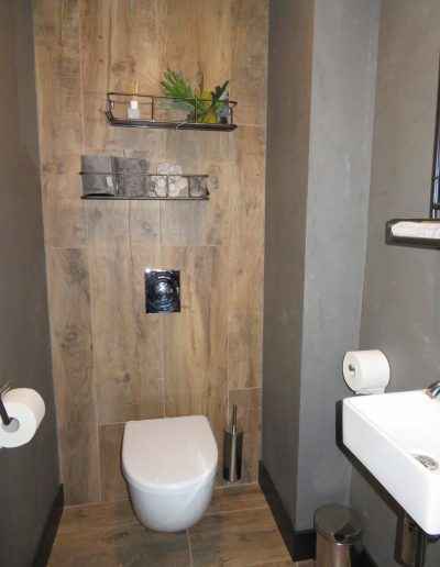 Foto 8. Hoe gaaf! Keramisch hout doorgetegeld op de achterwand van het toilet en aan de zijkant betonciré van vtwonen