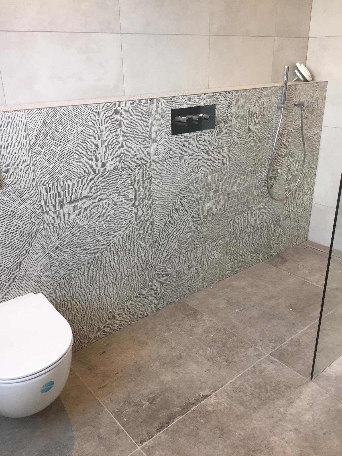 badkamer in aardetinten met o.a. een tegel van een Nederlandse student die een ontwerpwedstrijd heeft gewonnen.